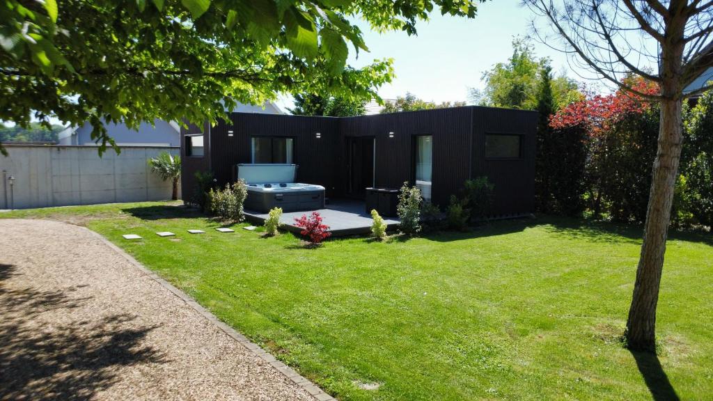 a small backyard with a black house at Villa Louméa - Le Loft avec jacuzzi in Friesenheim