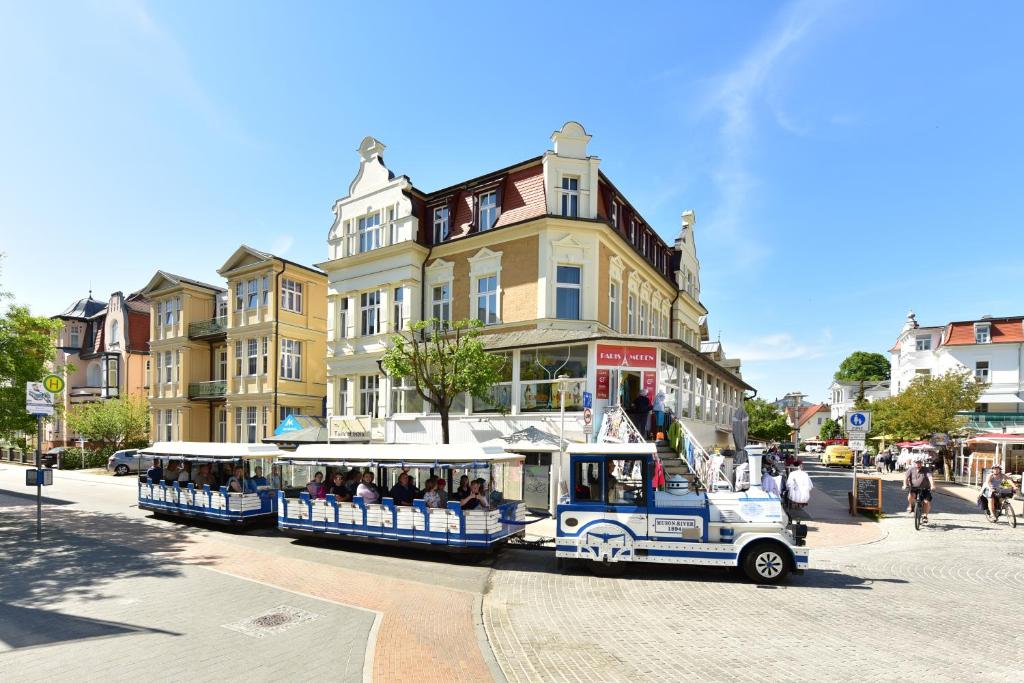 a trolley filled with passengers riding down a city street at Hotel Meereseck in Bansin