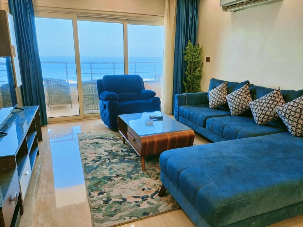 Join Inn Apartments في الإسكندرية: غرفة معيشة مع أريكة زرقاء وطاولة