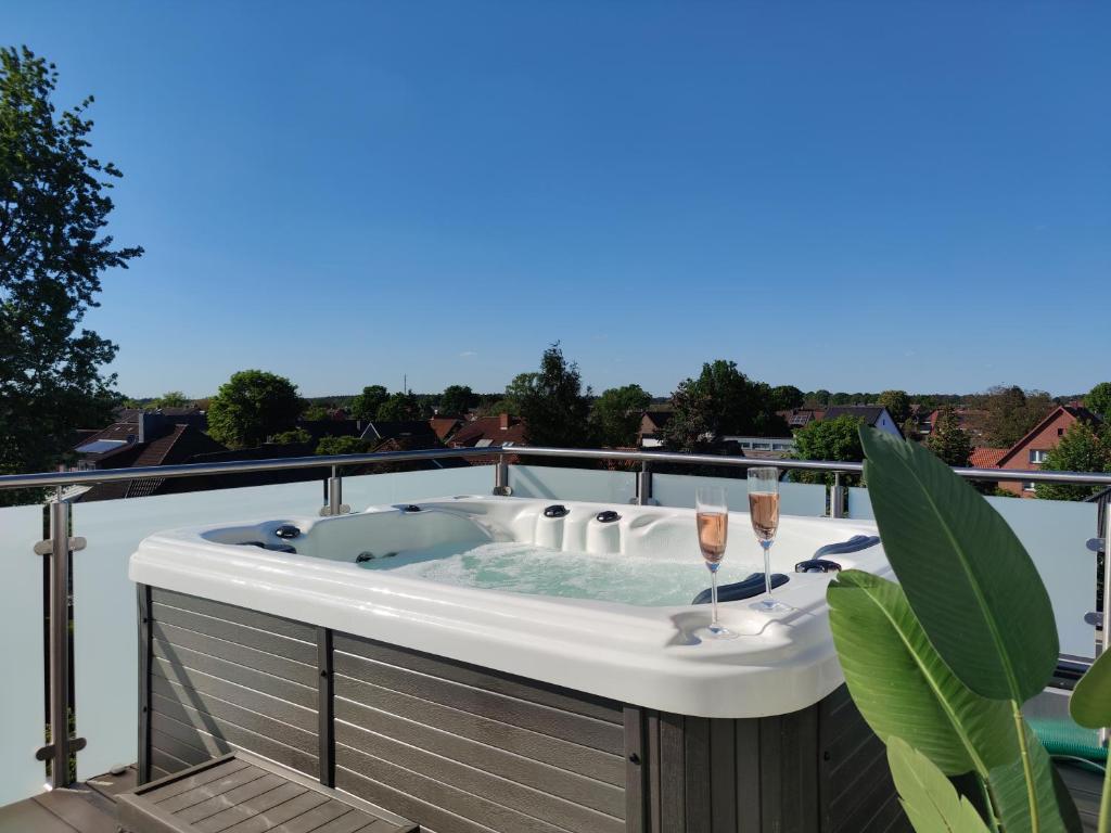 a hot tub on a balcony with champagne glasses at Penthouse mit Whirlpool im Herzen von Niedersachsen in Burgwedel