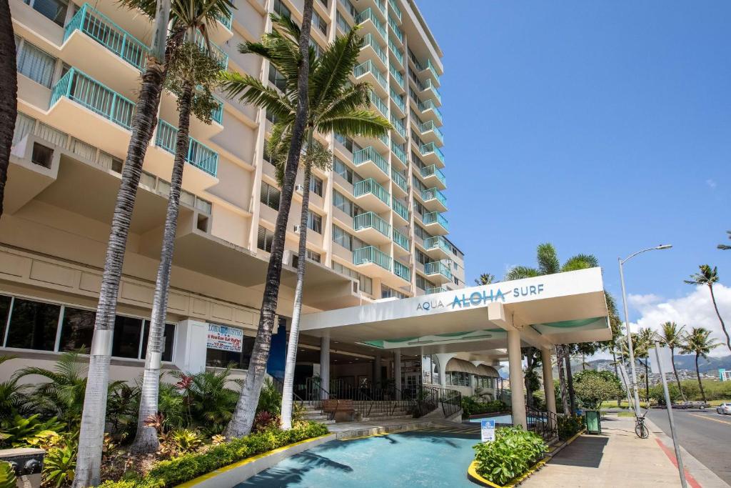 a hotel with a swimming pool in front of a building at Aqua Aloha Surf Waikiki in Honolulu