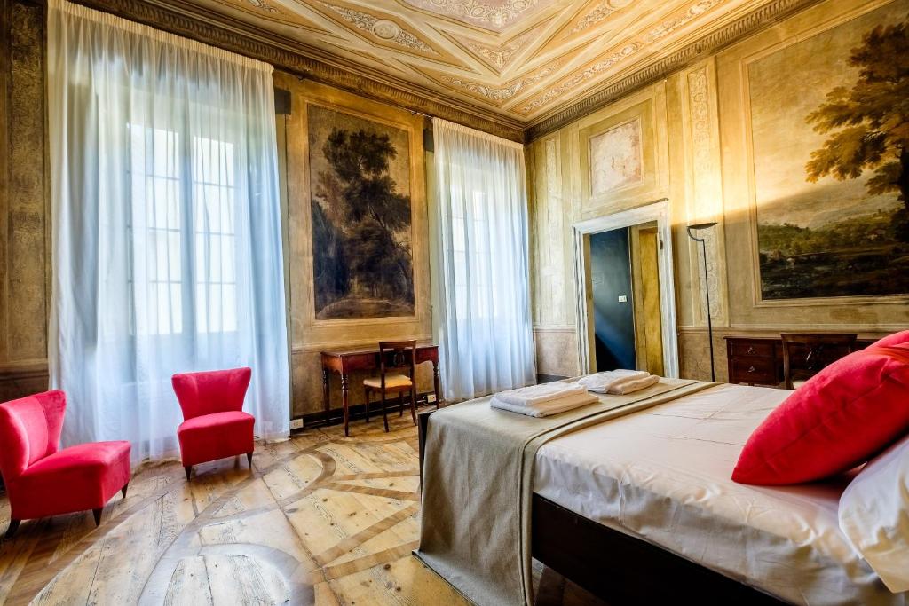 a bedroom with a bed and two red chairs at PAO Apartment - Veronetta Luxury in Verona