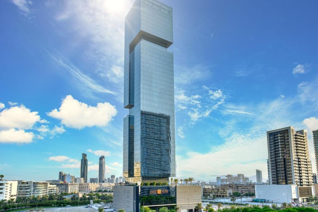 a rendering of a tall skyscraper in a city at The First Collection at Jumeirah Village Circle, a Tribute Portfolio Hotel in Dubai