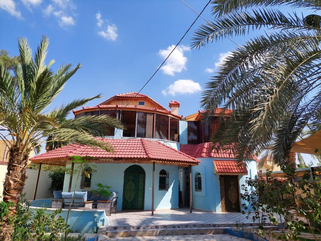 a house with a red roof and a palm tree at villa Rima in Shūnat Nimrīn