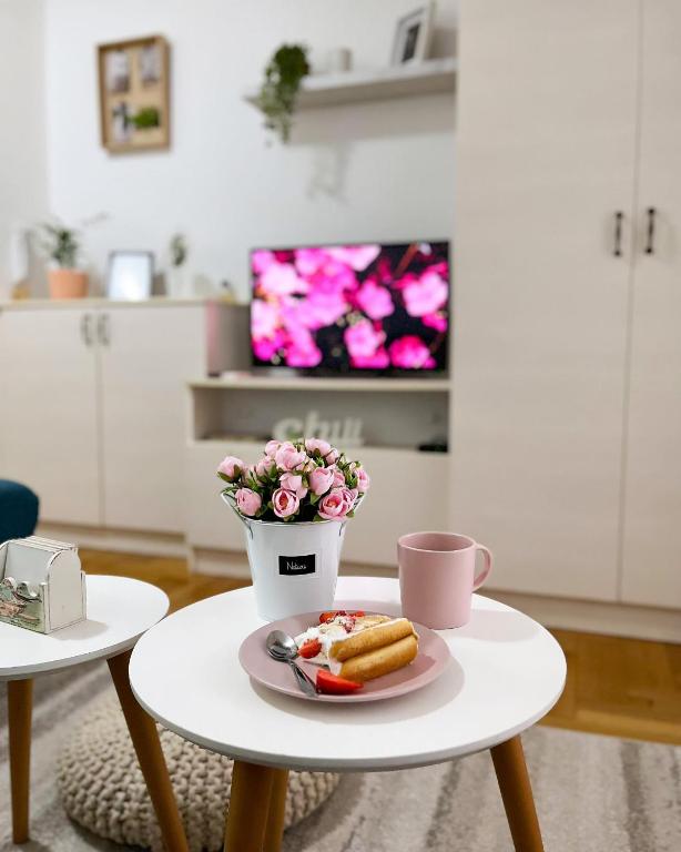 a table with a plate of food and a cup of coffee at Apartment Atria in Vrnjačka Banja