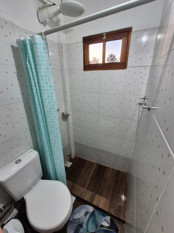 een kleine badkamer met een toilet en een raam bij GB Hostel IG in Puerto Iguazú