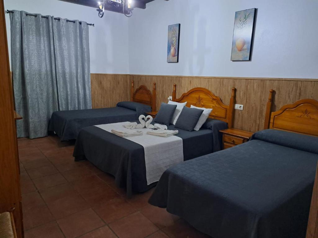 um quarto de hotel com duas camas e uma mesa em Hostal Breñaverde em Gaucín
