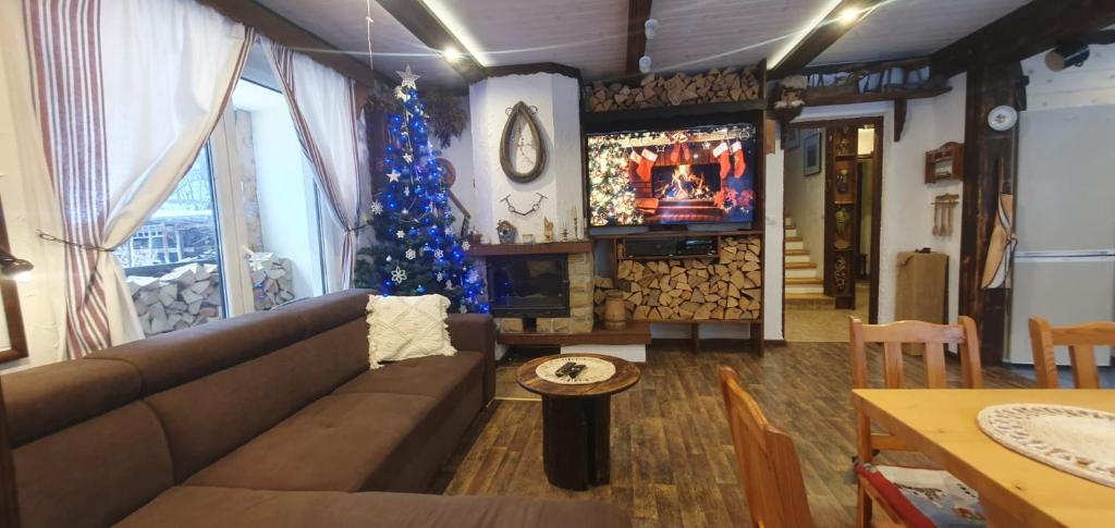 a living room with a couch and a christmas tree at Chata Lisiczka in Piwniczna-Zdroj