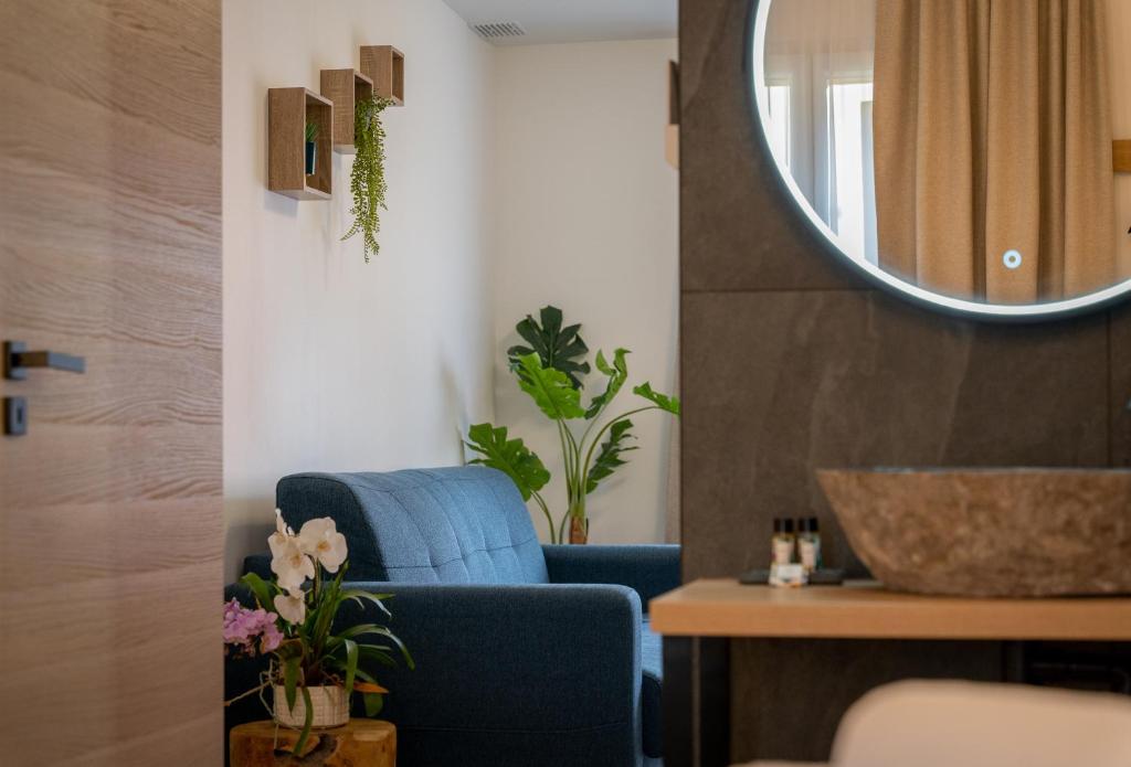 un salon avec une chaise bleue et un miroir dans l'établissement Superbe Appartement - Centre Mandelieu, à Mandelieu-la-Napoule