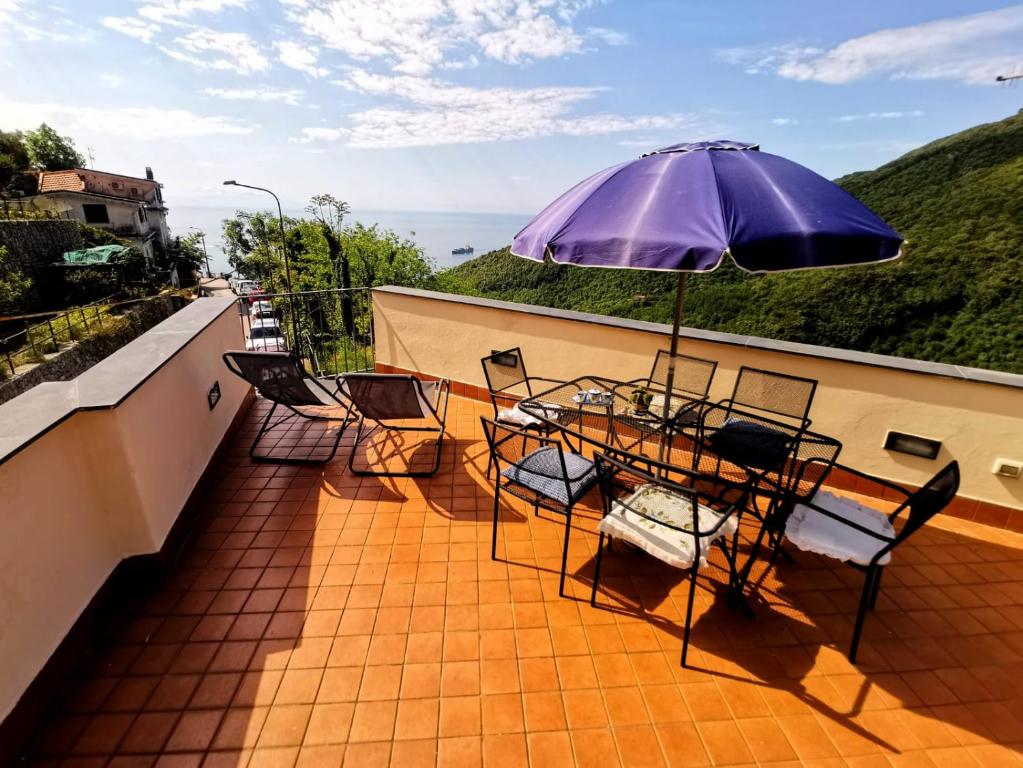 a balcony with a table and chairs and an umbrella at Cristina Home in Vietri