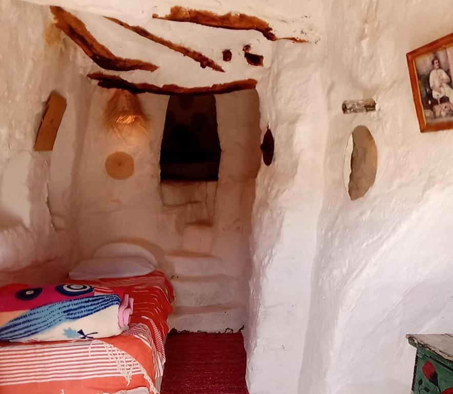 a room with a bed inside of a cave at Gite Douiret in Ad Duwayrāt