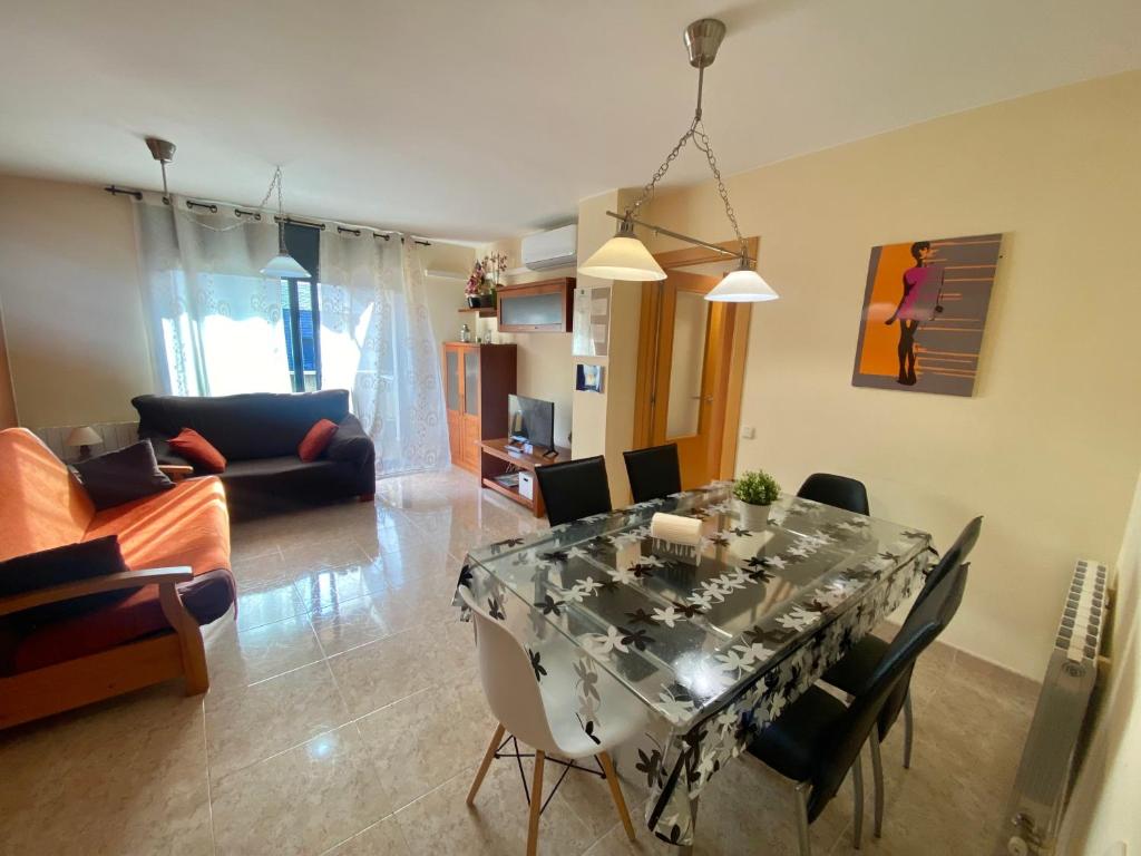 een woonkamer met een glazen tafel en stoelen bij Apartamento Cinca Pirineo en Aínsa in Aínsa