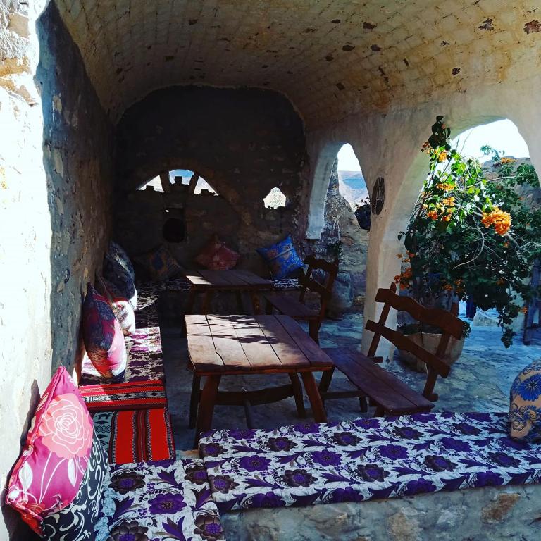 a room with a table and benches in a cave at Gite Douiret in Ad Duwayrāt