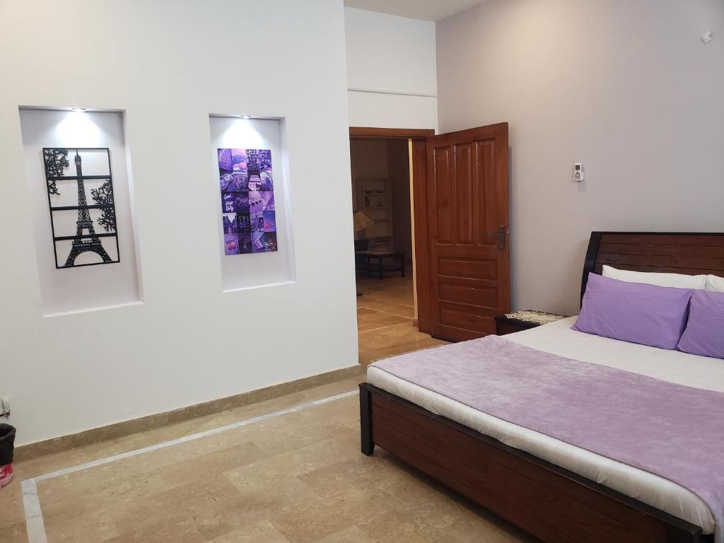 una camera da letto con letto e cuscini viola di lalic lavender a Islamabad