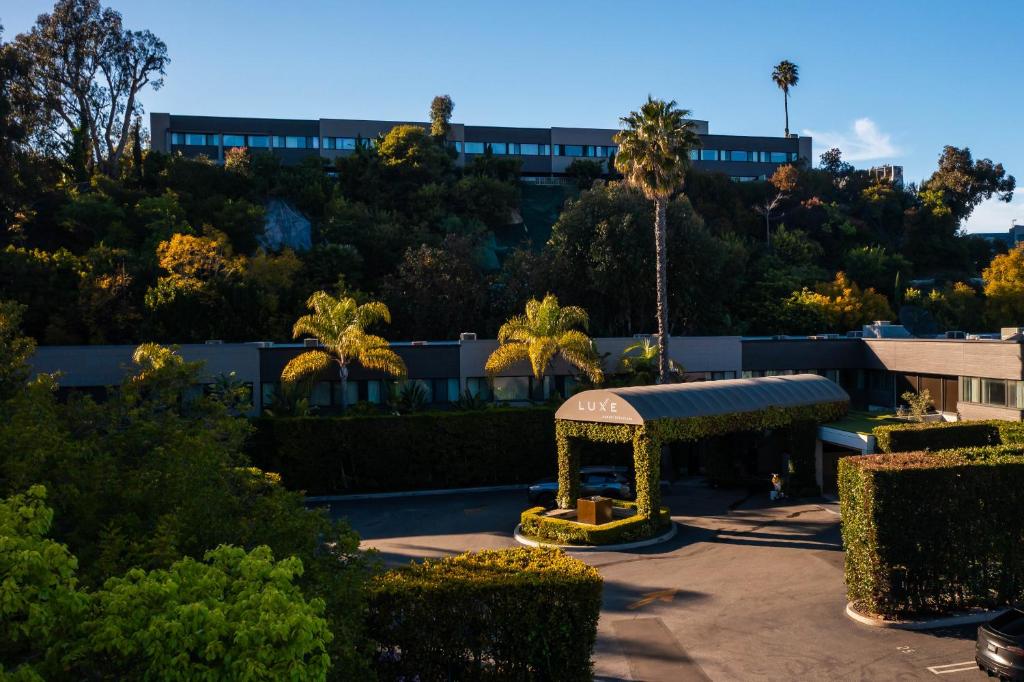 Blick auf einen Park mit einem Gebäude im Hintergrund in der Unterkunft Luxe Sunset Boulevard Hotel in Los Angeles