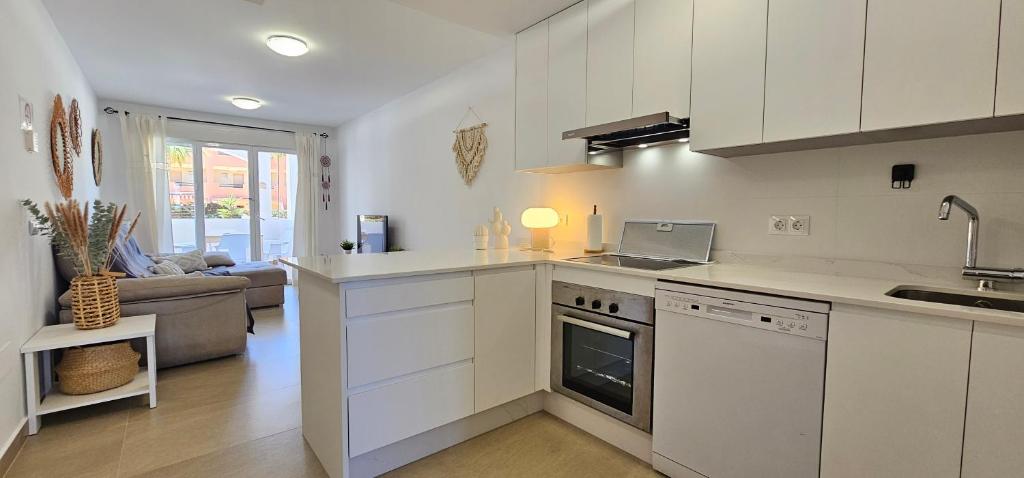 Kuchyň nebo kuchyňský kout v ubytování Homes of Spain, Apartamentos Paraíso Vera Playa, Fatu Hiva, Bajo A con piscina privada en jardín privado, PRIMERA LINEA de PLAYA, WIFI