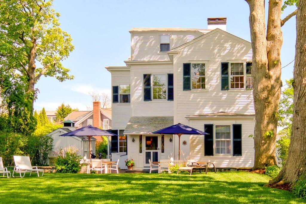 エドガータウンにあるWest Wing of Captain Morse House Waterfront, Townの庭にテーブルとパラソルが置かれた白い家