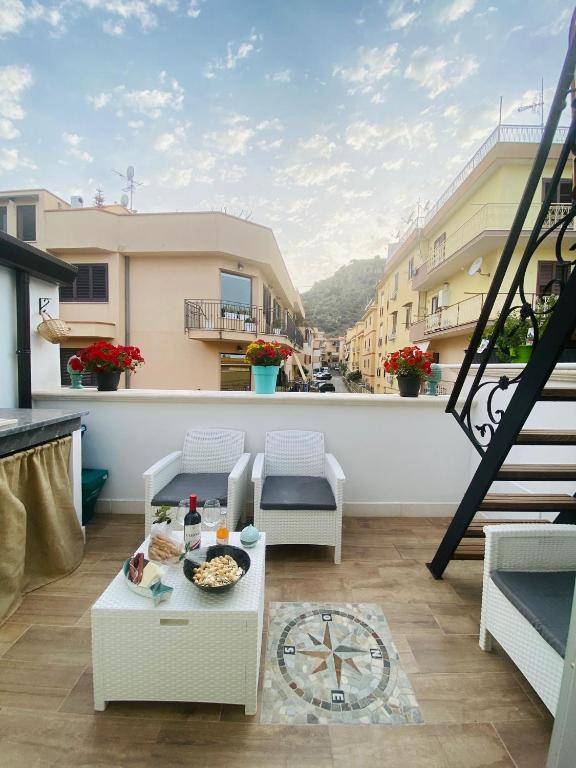 a balcony with a table and chairs on a building at Donna Carmela in Porticello