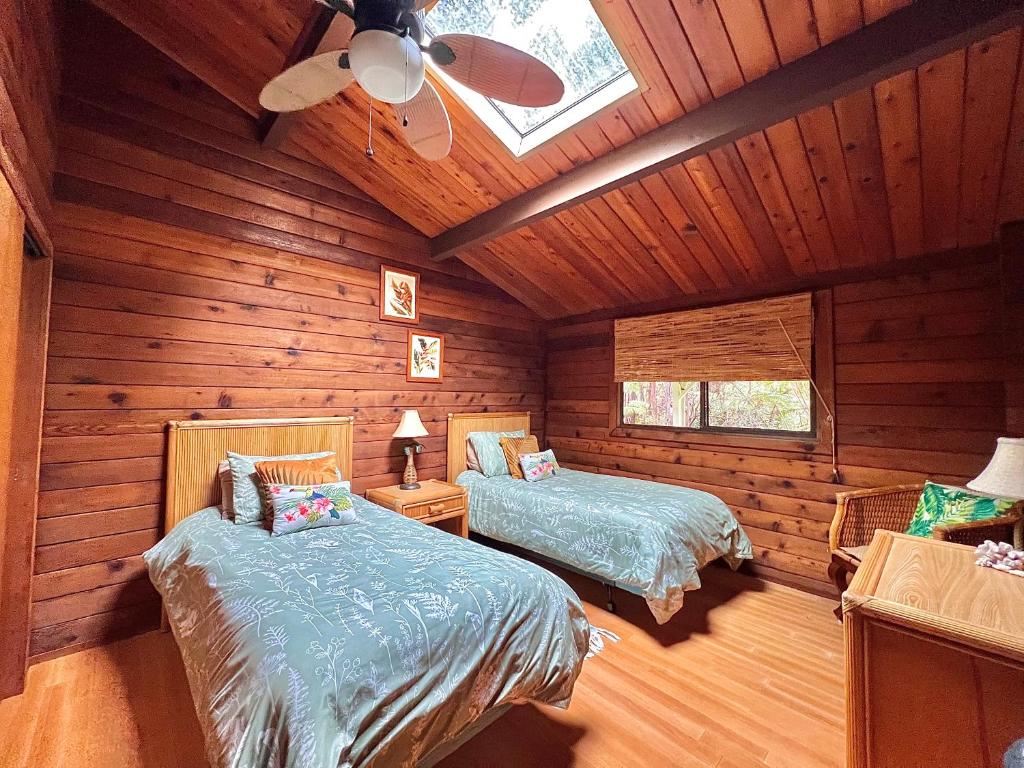 a bedroom with two beds in a log cabin at Hale Sweet Hale as seen on HGTV in Volcano