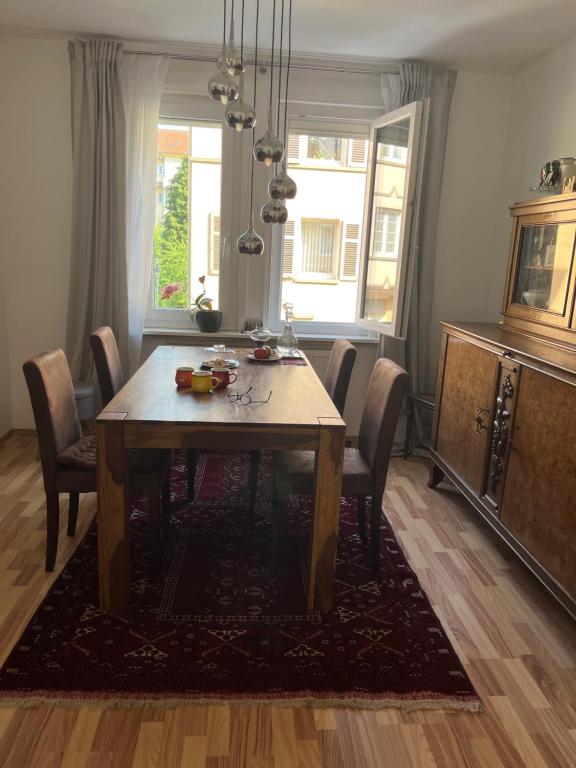 a dining room with a wooden table and chairs at Zimmer frei in Oberesslingen