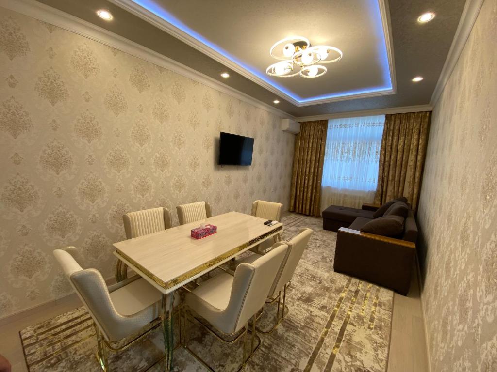 uma sala de jantar com uma mesa e cadeiras e um sofá em Spectre Neo Classic Cozy Home em Tashkent