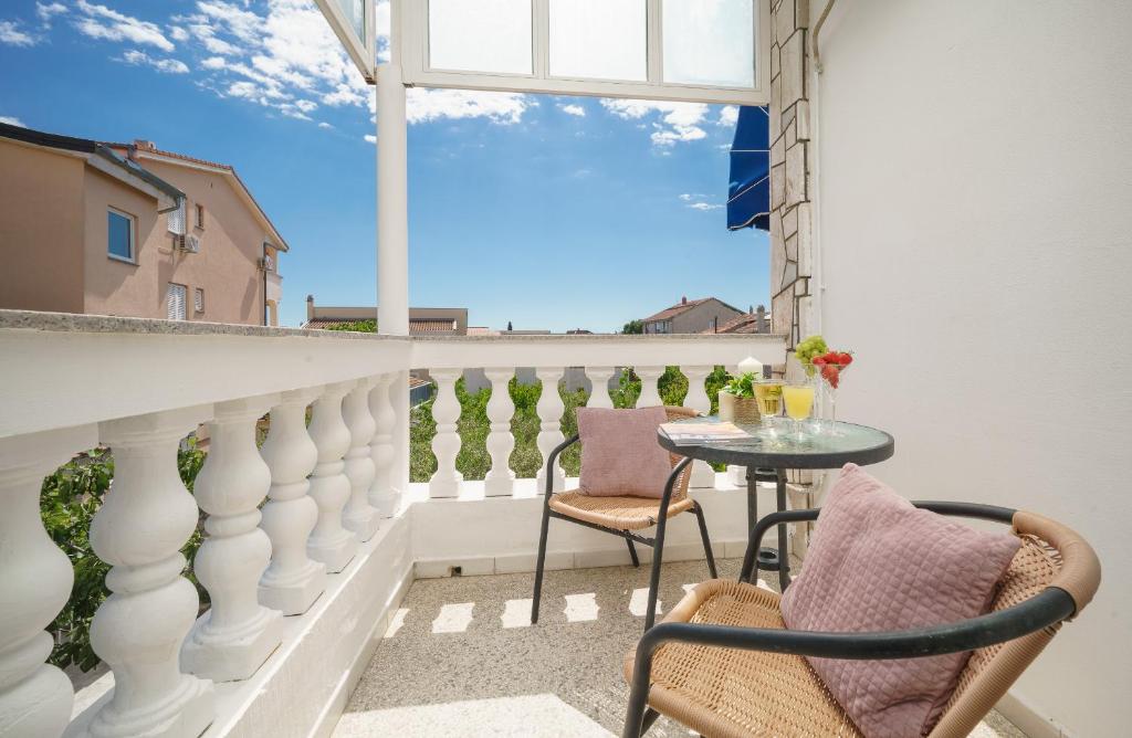 a balcony with a table and chairs and a window at Rooms Orion in Vodice