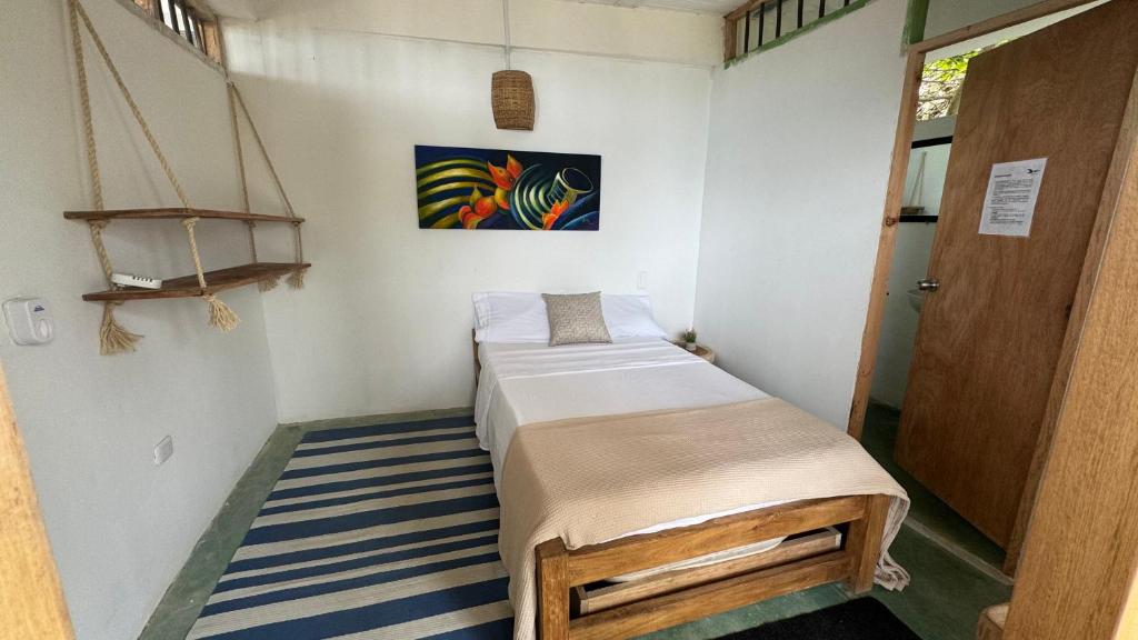 een kleine kamer met een bed en een deur bij Cabaña Punta Coral in Rincón