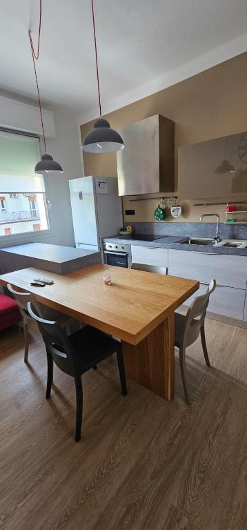 Una cocina con una mesa de madera y dos sillas. en A Casa Di Viola, en Casalecchio di Reno