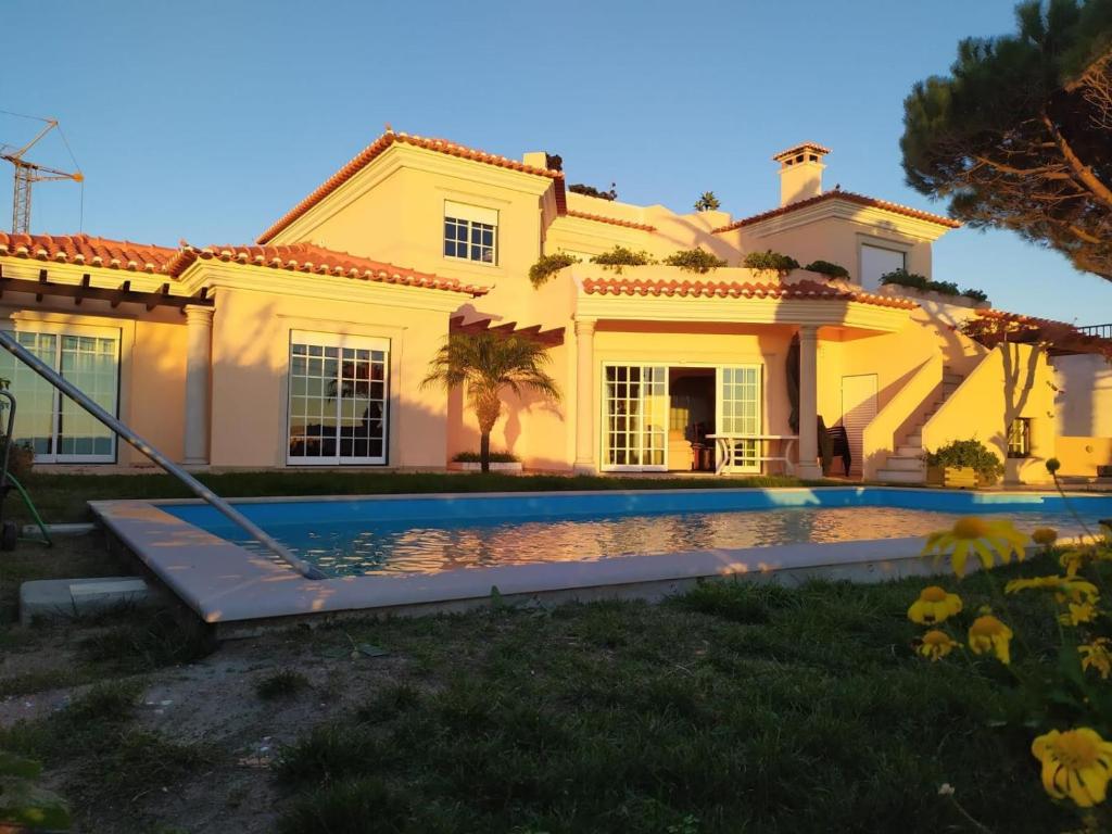 una casa con piscina frente a ella en Villa Terra da Eira-Sea view en Lourinhã