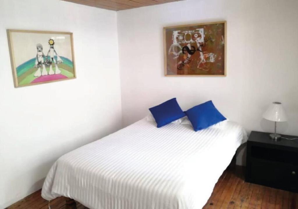 1 dormitorio con cama blanca y almohadas azules en Departamento en Casa Azul centro de SLP con jacuzzi y terraza - INMOTEGA, en San Luis Potosí