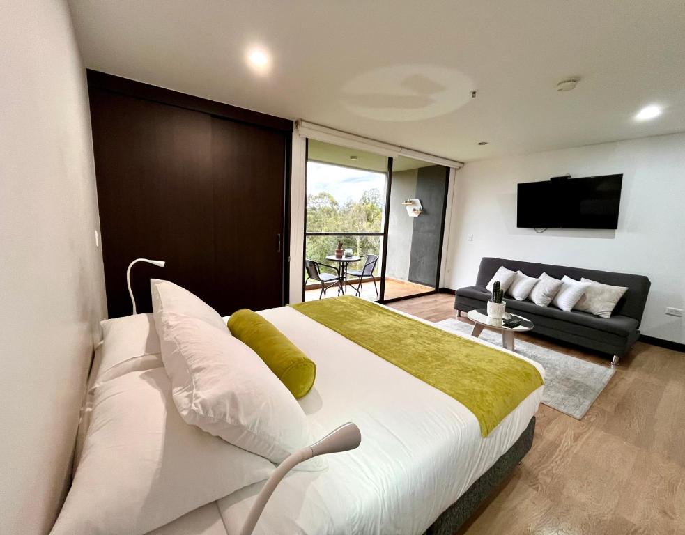 um quarto com uma cama grande e uma sala de estar em Hotel Rioverde em Rionegro