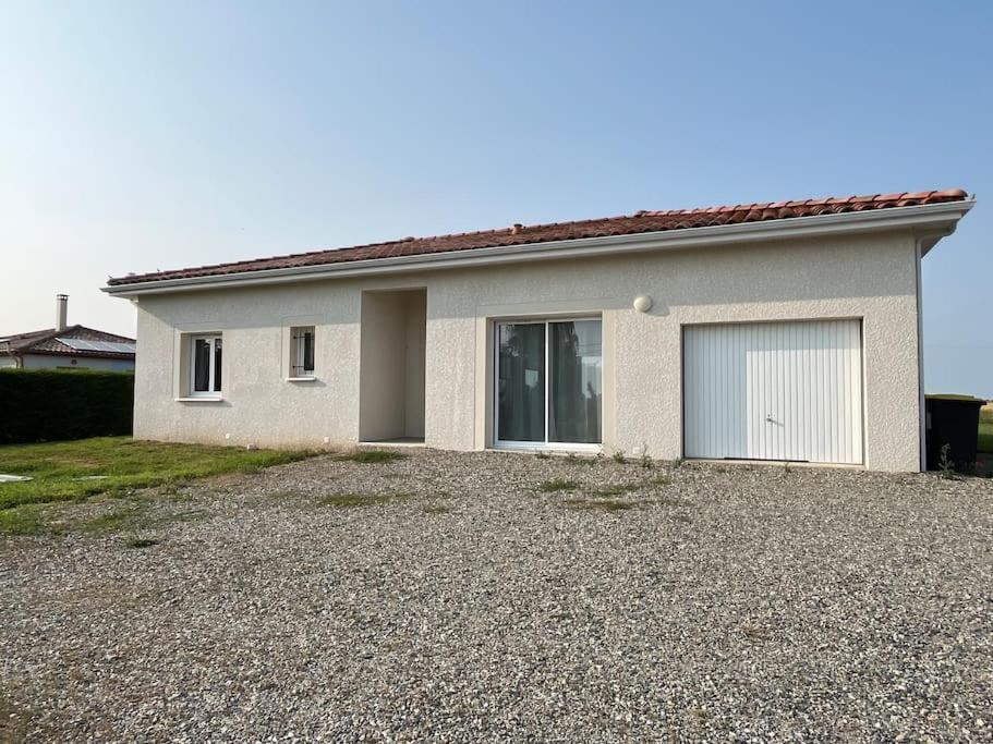 a house with a garage and a gravel driveway at Maison à Saint elix le château in Saint-Élix-le-Château