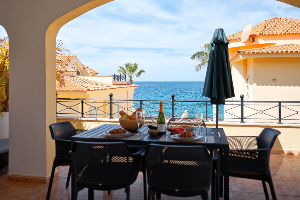 a table and chairs with a view of the ocean at Ocean View Vila with Private Jacuzzi in Los Cristianos