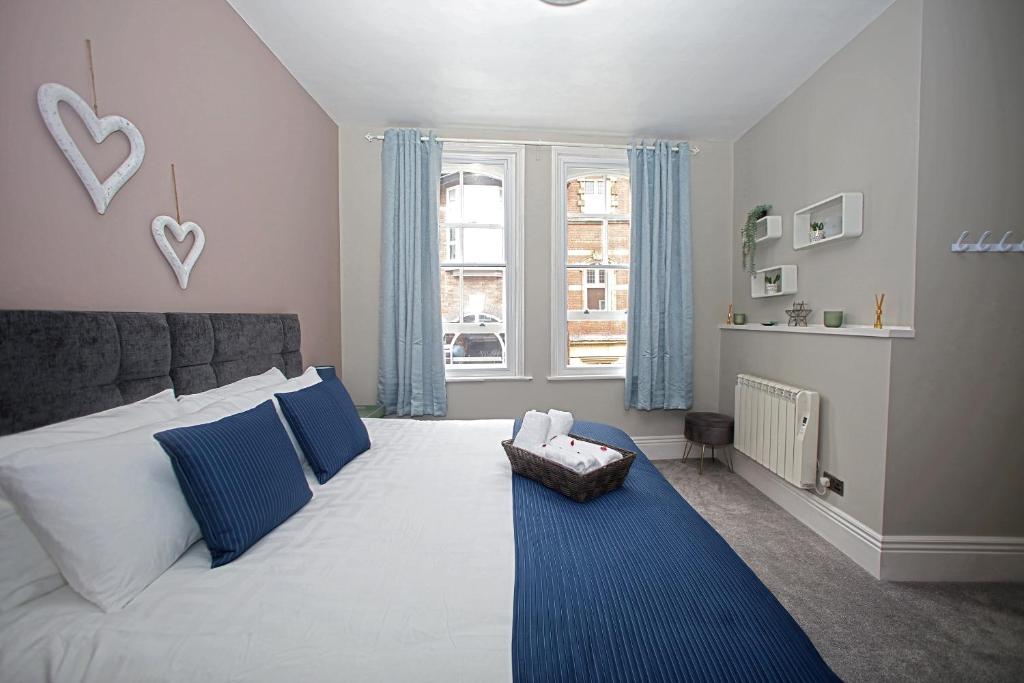 ヨークにあるSkeldergate View Apartmentsのベッドルーム1室(青い枕のベッド1台、窓付)