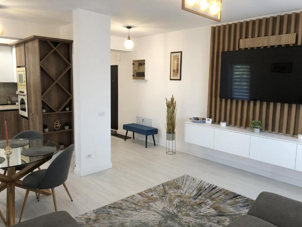 uma sala de estar com uma grande televisão de ecrã plano na parede em Comfort Residence Luxury Apartment em Craiova