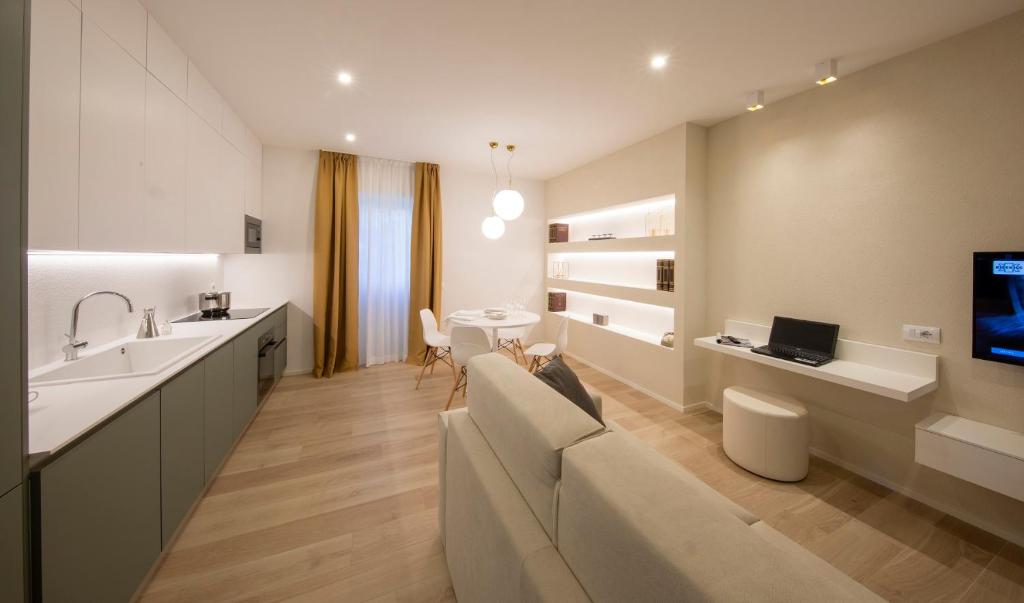 Il comprend un salon doté d'un canapé et une cuisine équipée d'une télévision. dans l'établissement Residence Casa Coppa Appartamento Aster, à Omegna