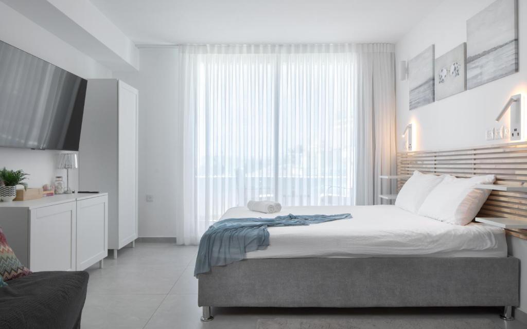 a bedroom with a bed and a large window at סוויטה עם נוף וצמודה לים במתחם SeaSide היוקרתי עם בריכה - By SEAELO EILAT in Eilat