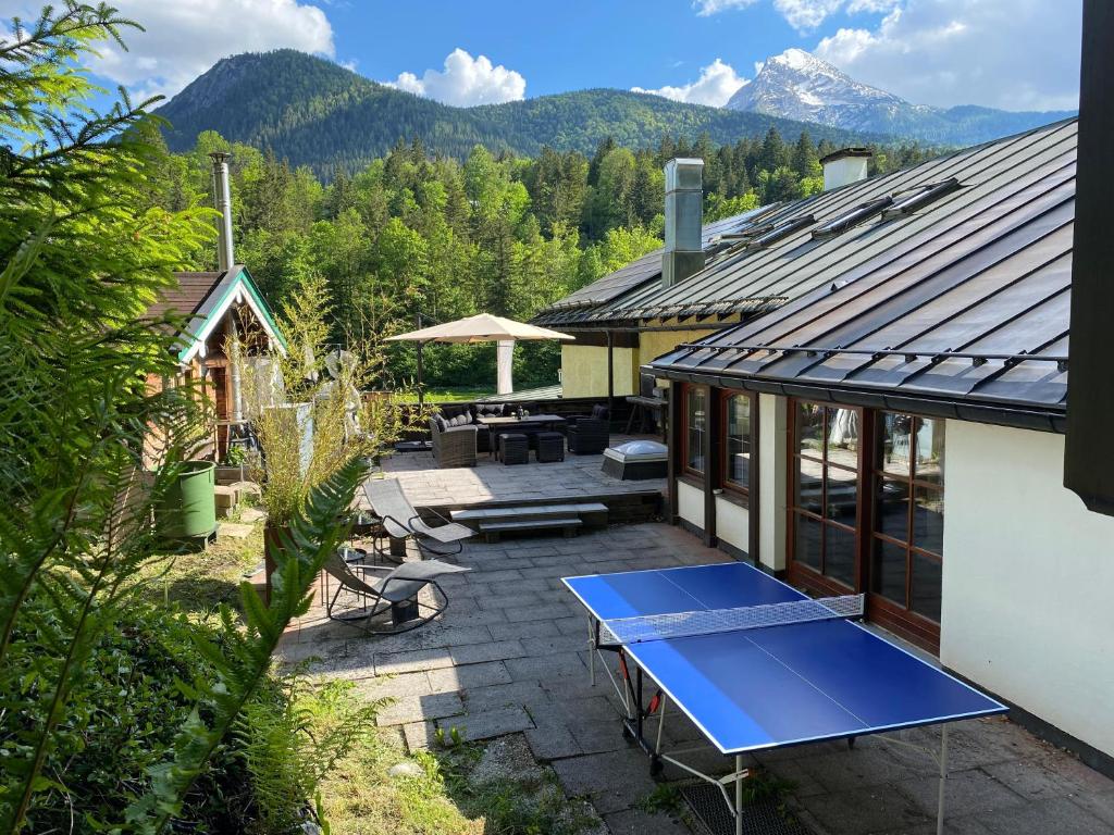 ビショフスヴィーゼンにあるC4S COME4STAY - Alpenblick Watzmann-Kehlstein - TOP Lage im Berchtesgadener Land I bis zu 10 Personen I große Terrasse mit Blick auf die Berge I Smart TV I Billiard I WLAN I kostenloser Parkplatzの家のパティオに青い卓球台がある