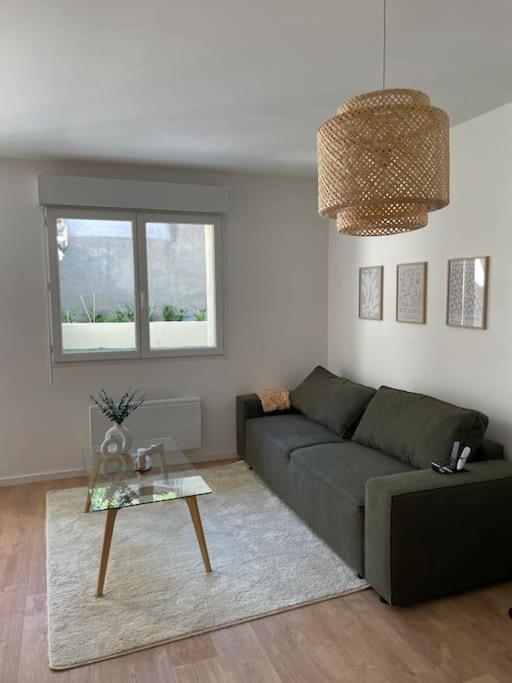 uma sala de estar com um sofá verde e uma mesa em Belle des champs - Loft avec spa em Labruguière