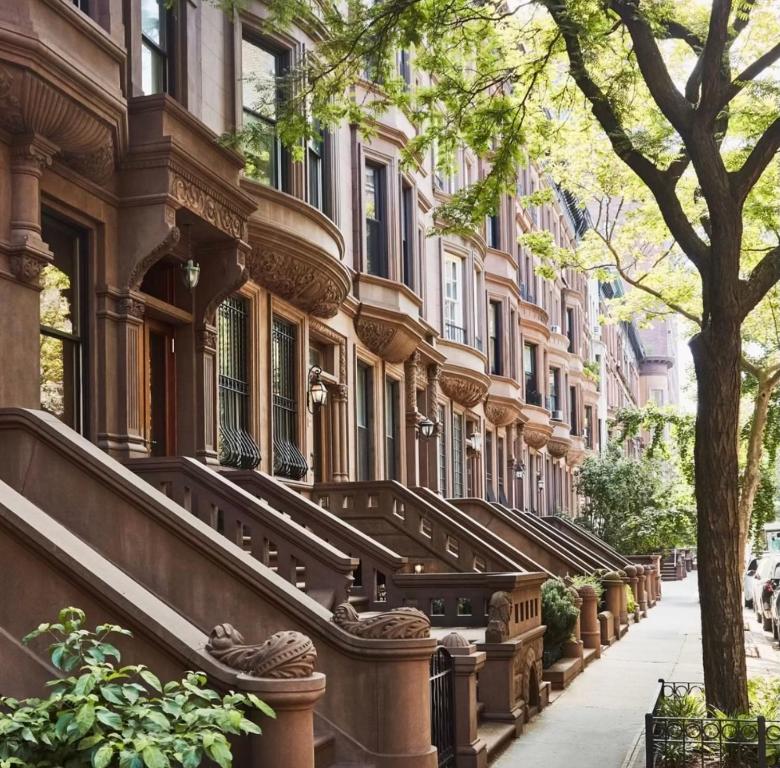 a row of buildings on a city street at Cozy Townhouse in Harlem in New York