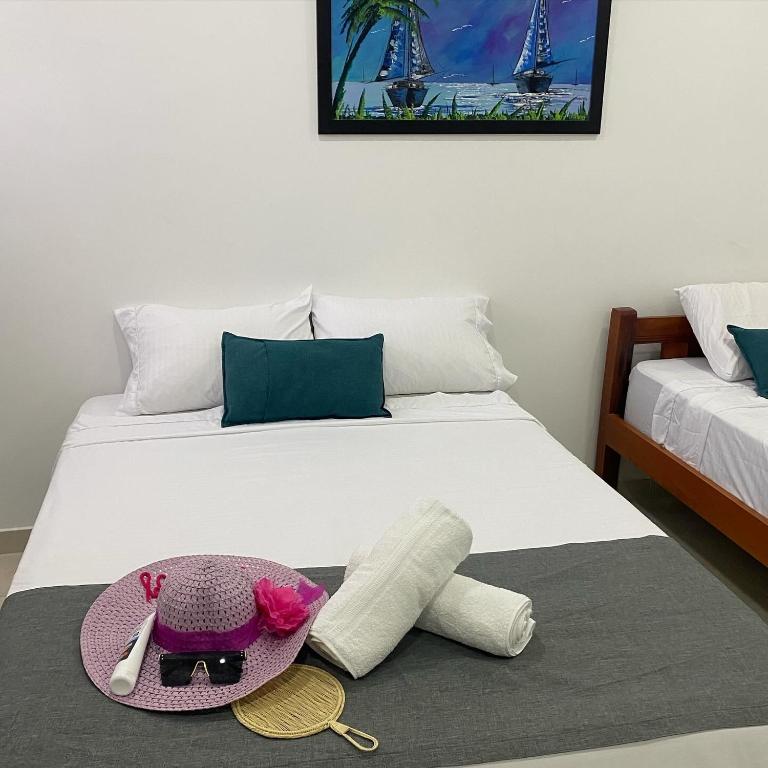 a bed with a hat and a stuffed animal on it at 22 Guest House in Santa Marta