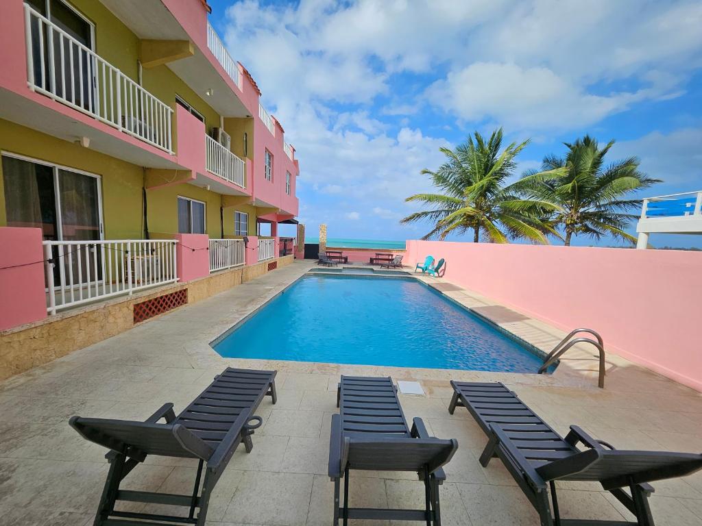 una piscina frente a un edificio con sillas en Selva Boutique Hotel - Luquillo Oceanfront Retreat - Adults Only, en Luquillo