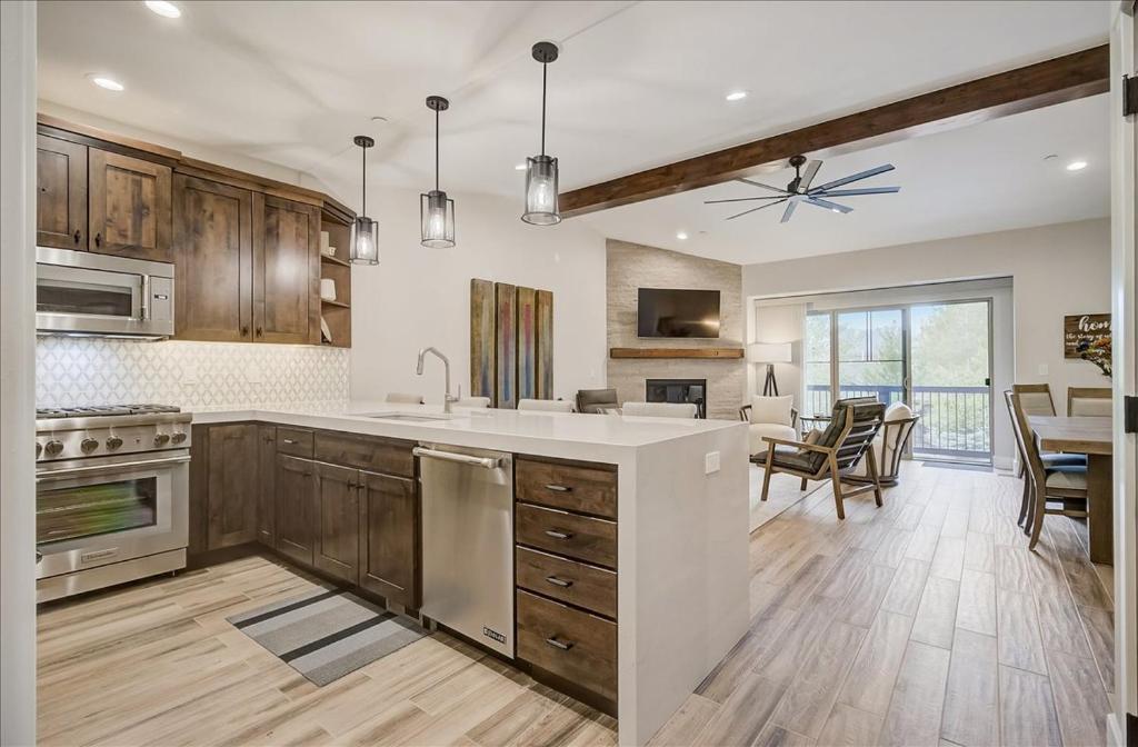 uma grande cozinha com armários de madeira e uma sala de jantar em Black Rock Ridge 14202 by Moose Management em Park City