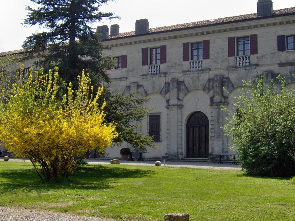 un edificio con un arbusto delante de él en Agriturismo Corte Virgiliana, en Virgilio