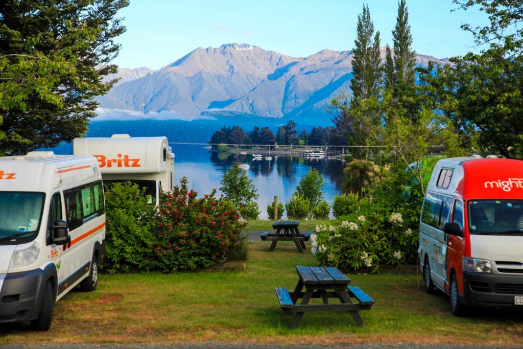 dois veículos estacionados num parque de campismo com vista para um lago em Te Anau Lakeview Holiday Park & Motels em Te Anau