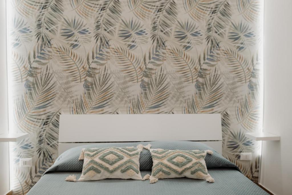 ein Schlafzimmer mit einem Bett mit einer Wand in der Unterkunft Barù home in centro in Palermo