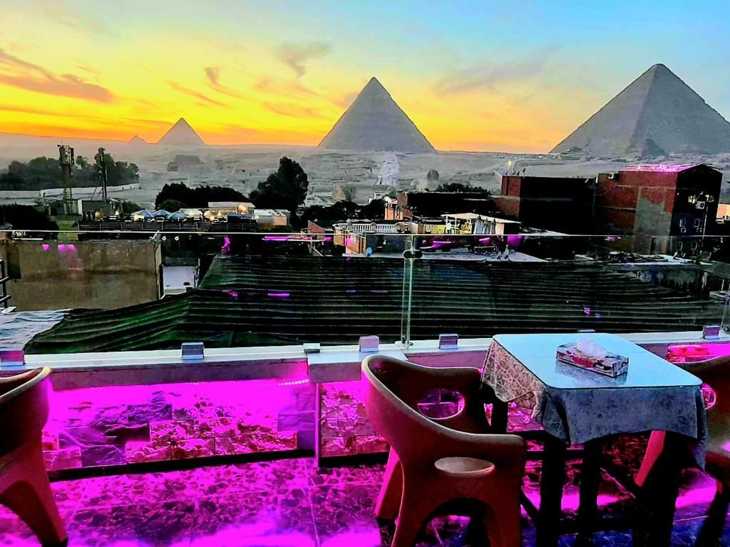 a restaurant with a table and a view of the pyramids at MagiC Pyramids INN in Cairo