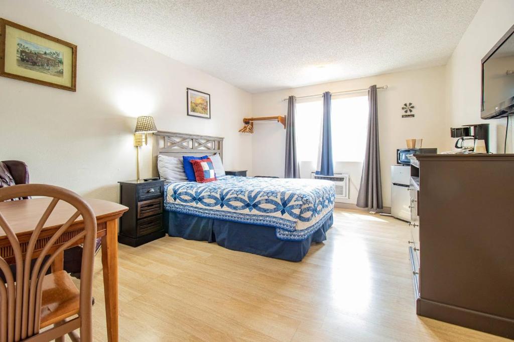 um quarto com uma cama, uma mesa e uma cozinha em Manitou Inn em Manitou Springs