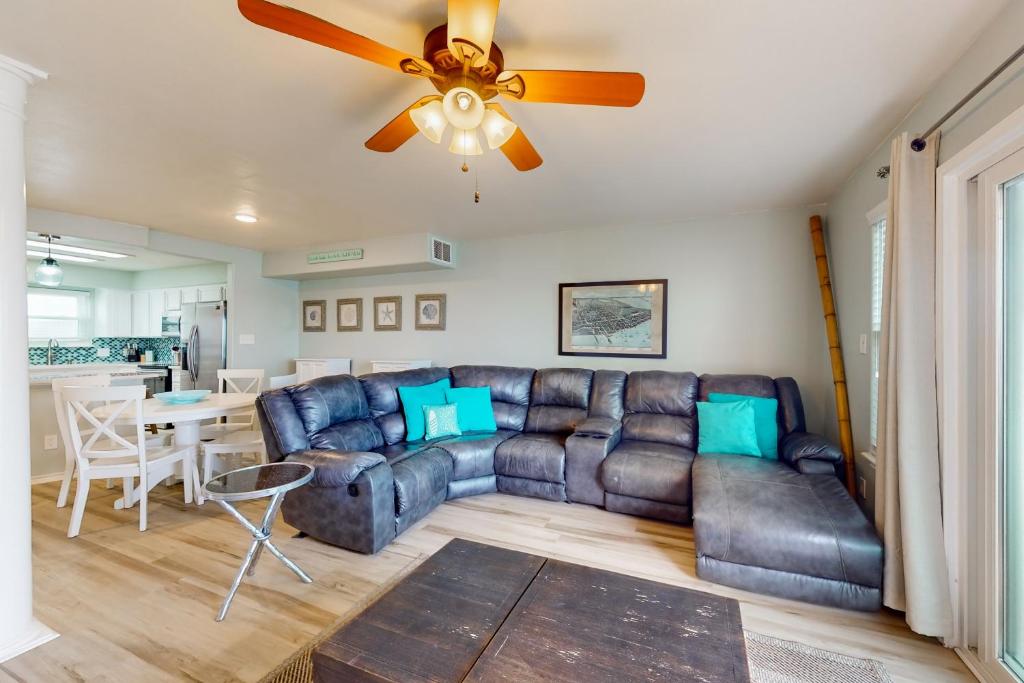 a living room with a couch and a ceiling fan at Blue Crab Bungalow in Padre Island