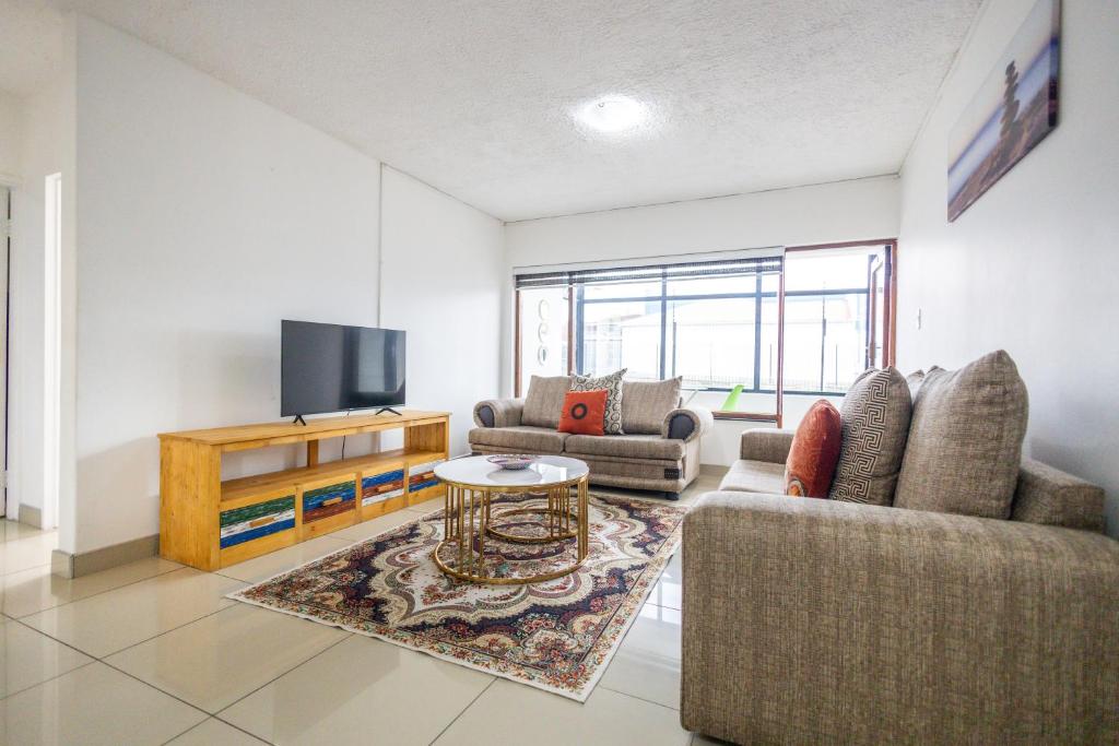 a living room with two couches and a tv at Safi Luxury Apartment - 3 in East London